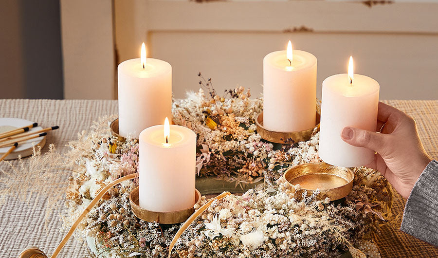 Adventskranz mit vier brennenden Kerzen und Trockenblumen