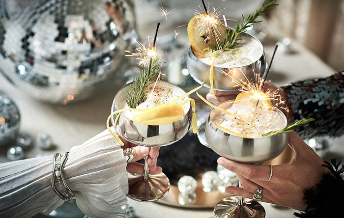 Blaues Cocktailglas mit Limettenscheibe und goldenem Strohhalm