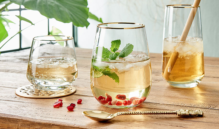 Elegante Cocktailgläser mit Goldrand und frischen Drinks