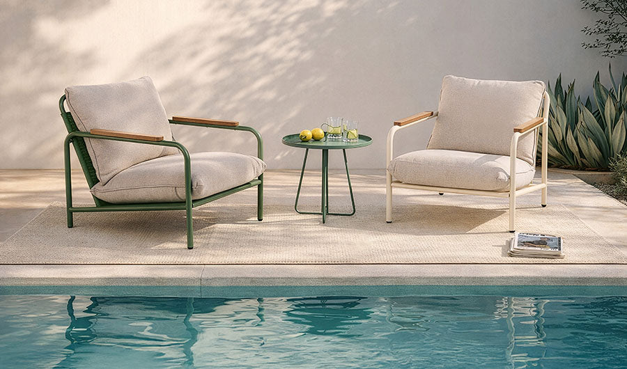 Zwei elegante Gartenloungesessel mit grünem Beistelltisch am Pool