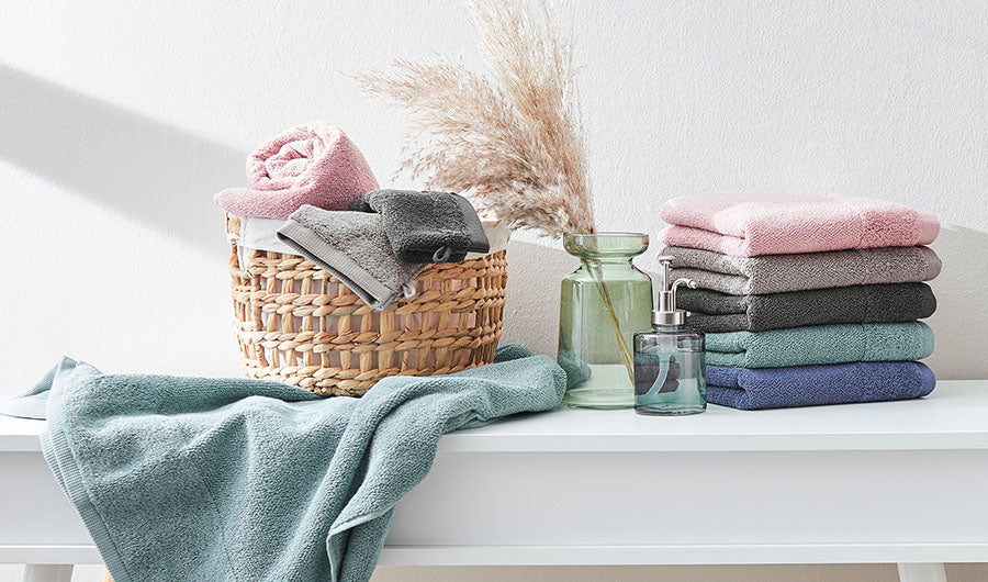 Handtücher in Rosa Grau und Petrol auf weißer Ablage