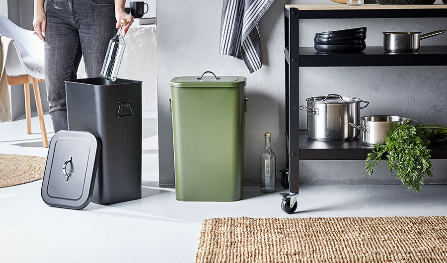 Schwarzer und grüner Mülleimer in moderner Küche mit Metallregal