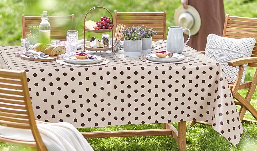 Beige Wachstischdecke mit braunen Punkten auf gedecktem Gartentisch