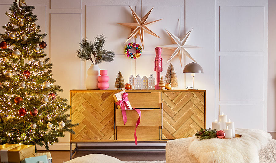 Festlich dekoriertes Wohnzimmer mit Sideboard Papiersternen und Christbaum