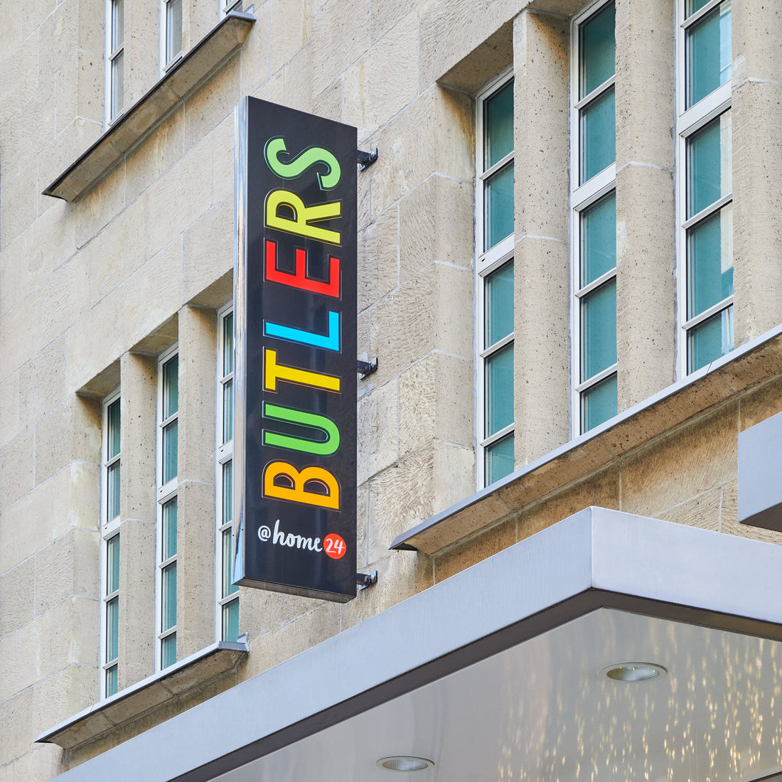Buntes BUTLERS @home24 Filialschild an Gebäudefassade