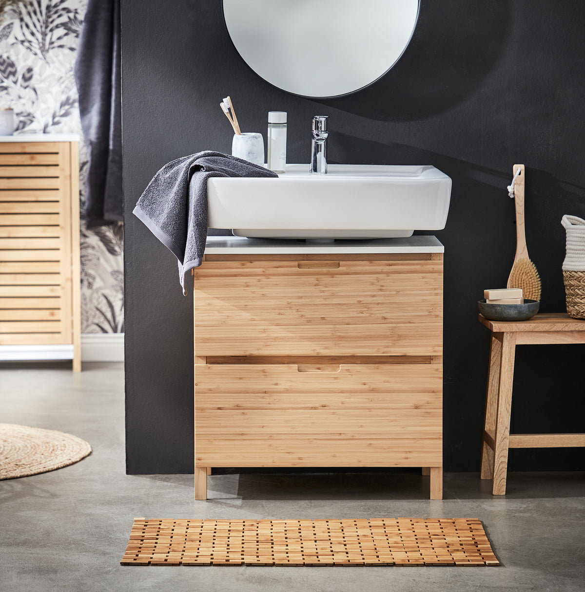 Bambus-Waschbeckenunterschrank mit Rundspiegel und grauem Handtuch