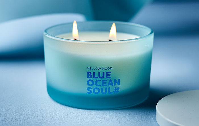 Brennende Blue Ocean Soul Duftkerze im mattierten hellblauen Glas mit zwei Dochten im maritimen Design.