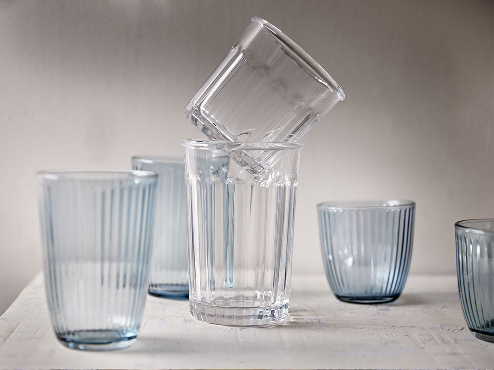 Stapelbare Trinkgläser aus Glas in Transparent und Hellblau mit vertikaler Rillenstruktur für den gedeckten Tisch.