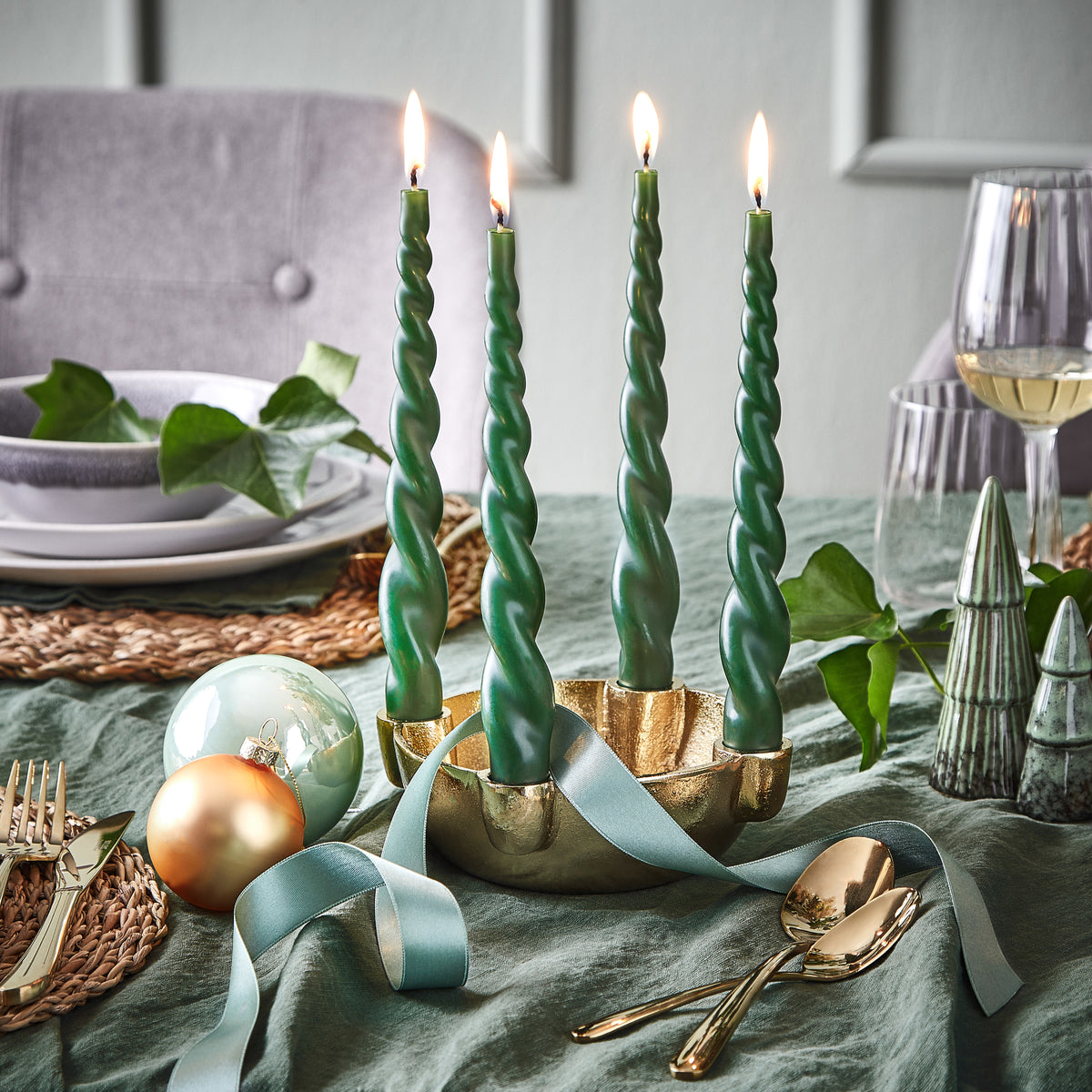 Goldener Adventskranz mit vier grünen gedrehten Stabkerzen