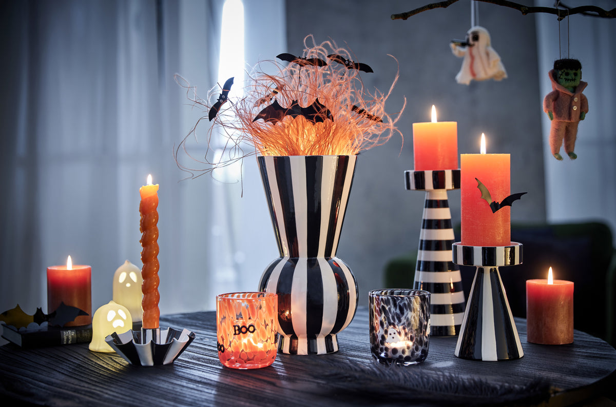 Halloween Deko mit gestreiften Vasen, orangen Kerzen und Gespenstern