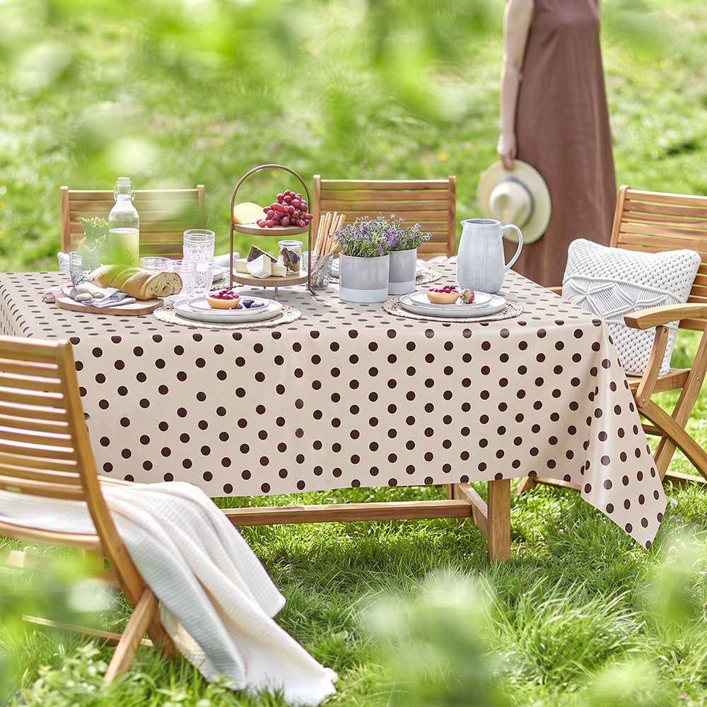 Beige Wachstischdecke mit Punkten auf gedecktem Gartentisch
