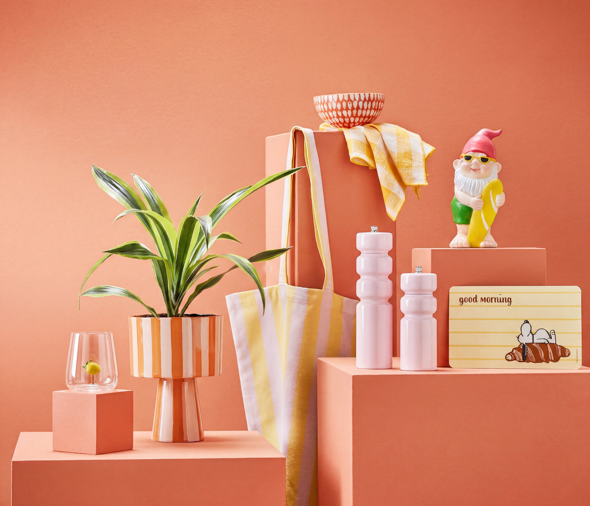 Bunte Wohnaccessoires und Deko vor orangefarbenem Hintergrund